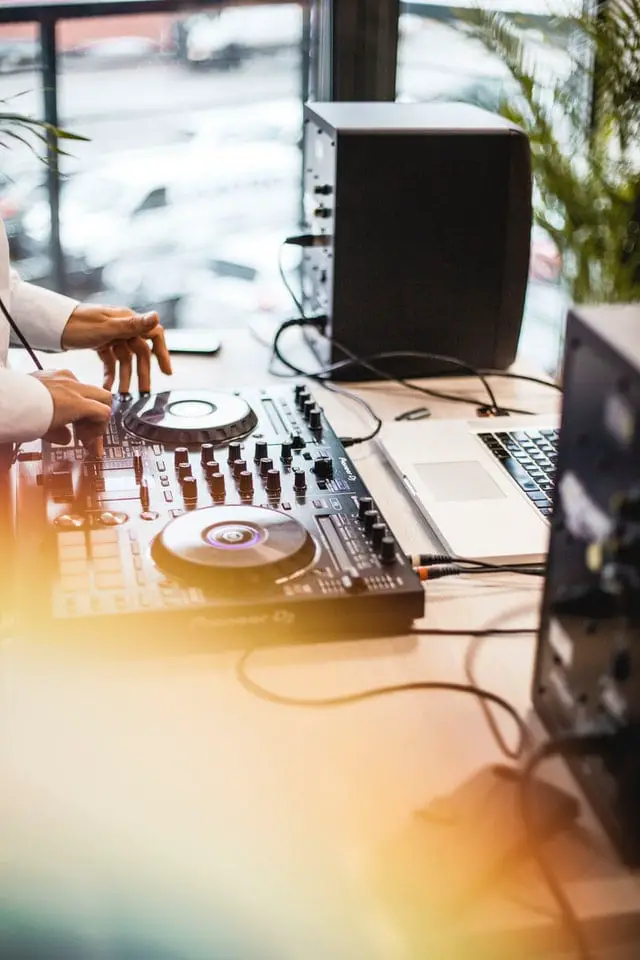 Platines et enceintes DJ sur un bureau.