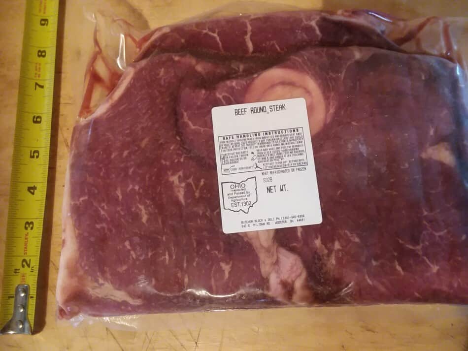 steak rond à côté du ruban à mesurer pour comparaison